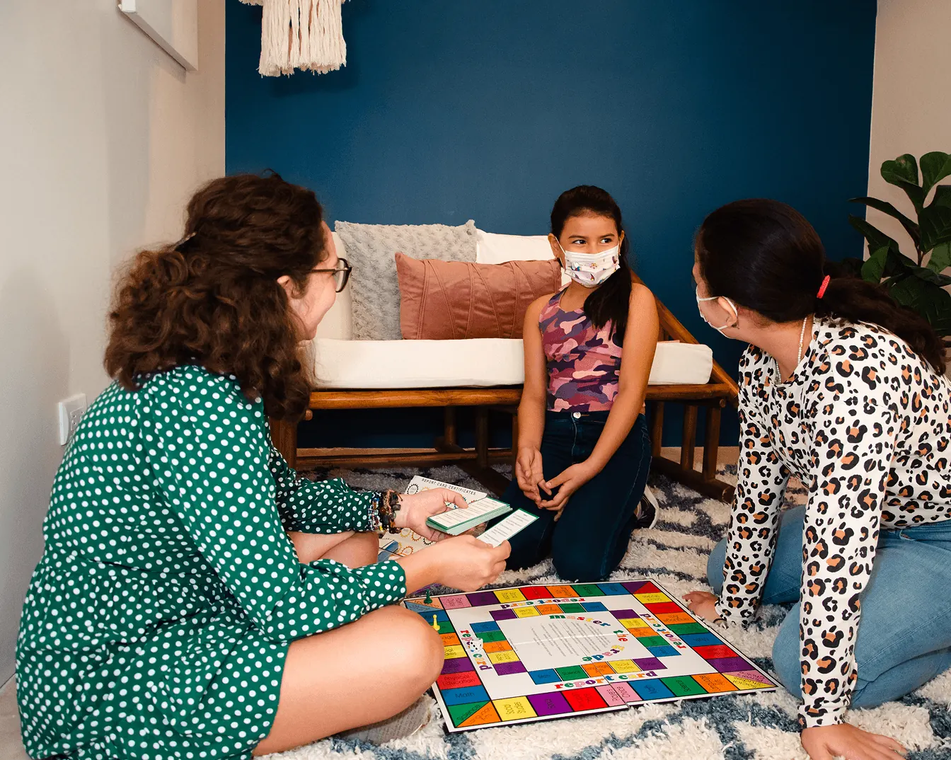 Psicóloga jugando un juego de mesa con una niña en terapia infantil