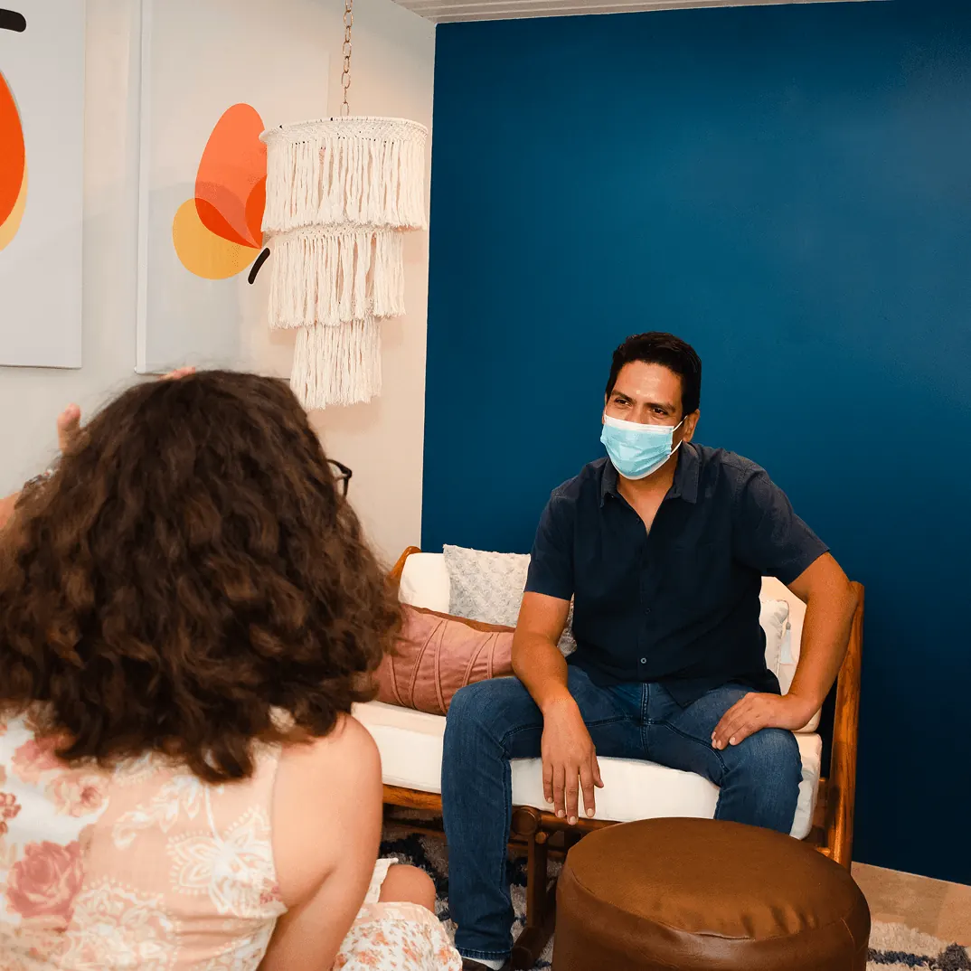 Psicóloga conversando con un paciente adulto en terapia